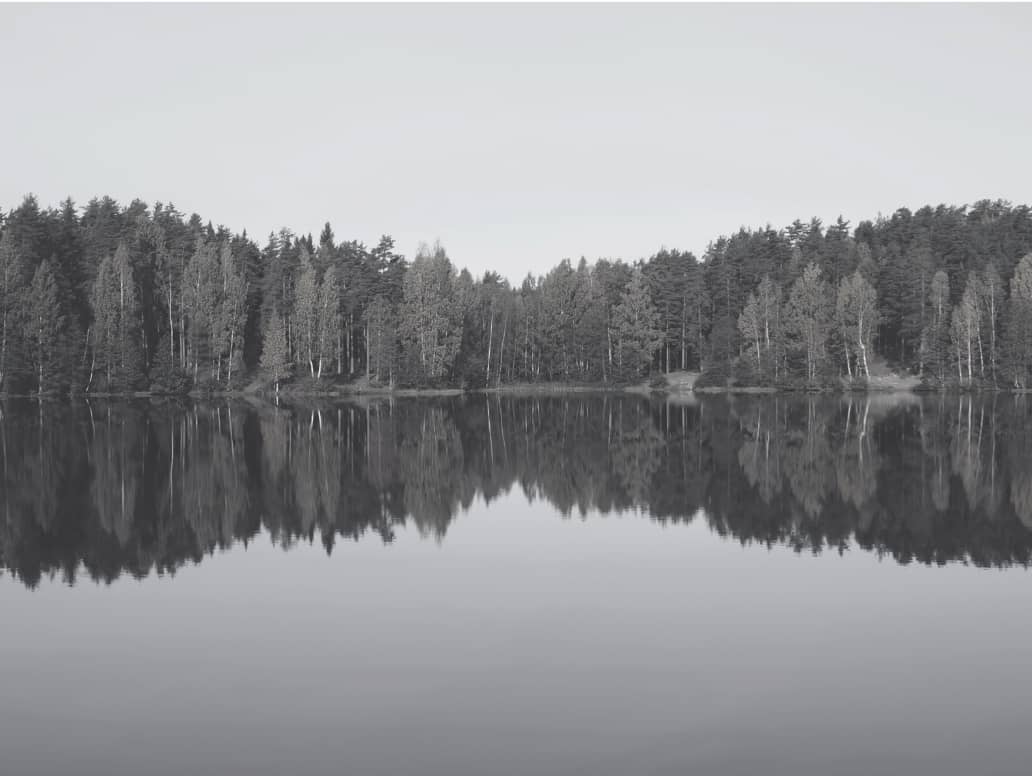 Spegelblank sjö som symboliserar lugn, balans och sunda gränser för att släppa oro