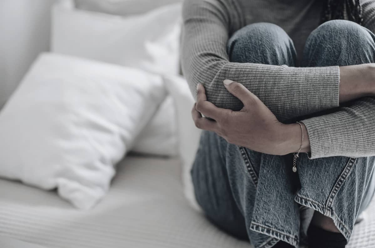 När omtanke blir kontroll och medberoende, en kvinna sitter hopkrupen i soffan