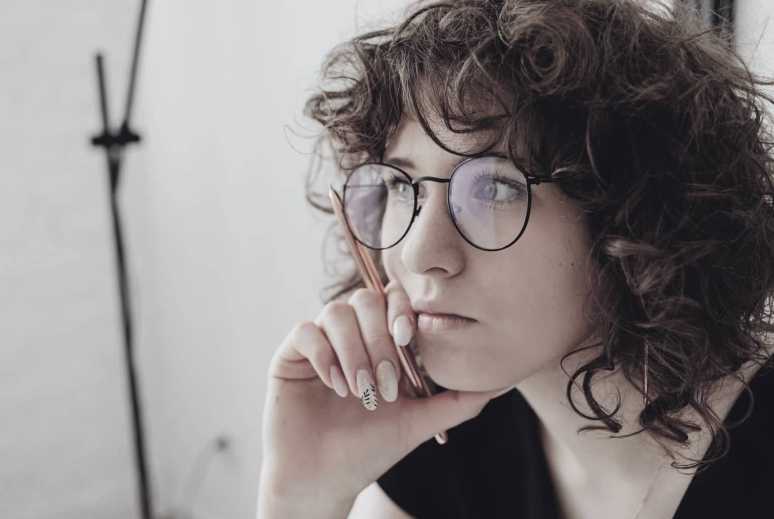 Kvinna med glasögon funderar över vad people-pleasing innebär