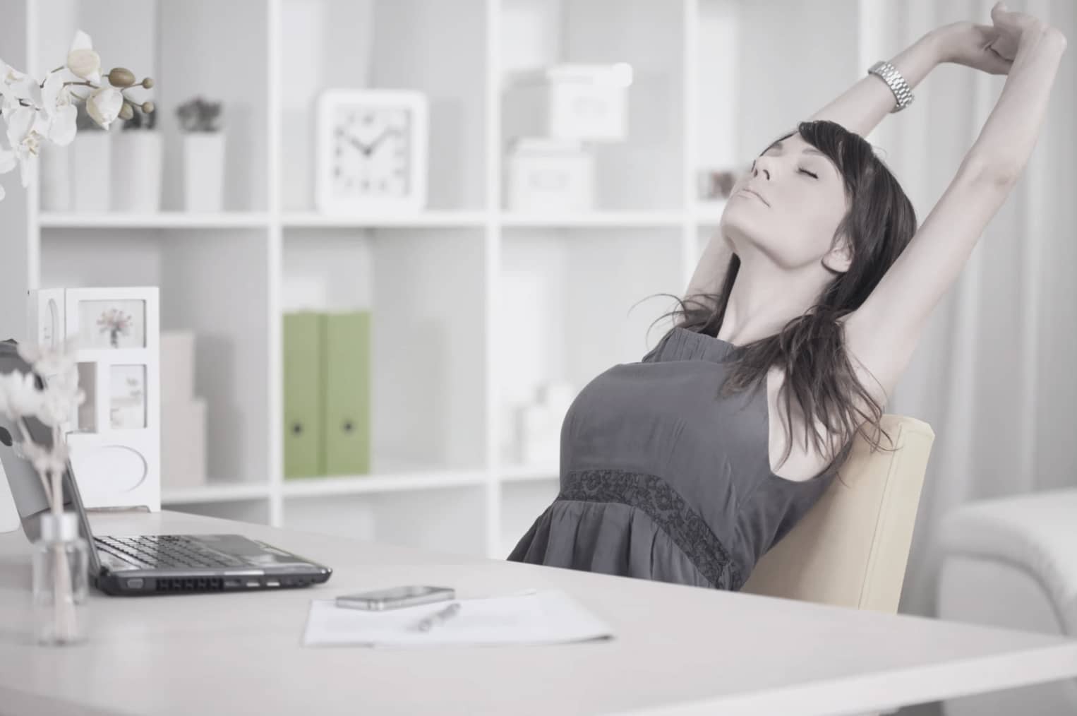 kvinna som sträcker på sig vid skrivbord efter att ha börjat bryta medberoende